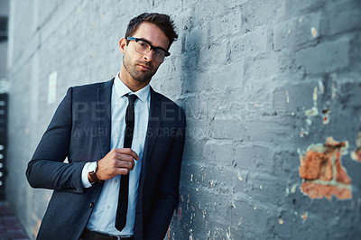 Buy stock photo Cropped portrait of a handsome young businessman standing against a grey facebrick wall