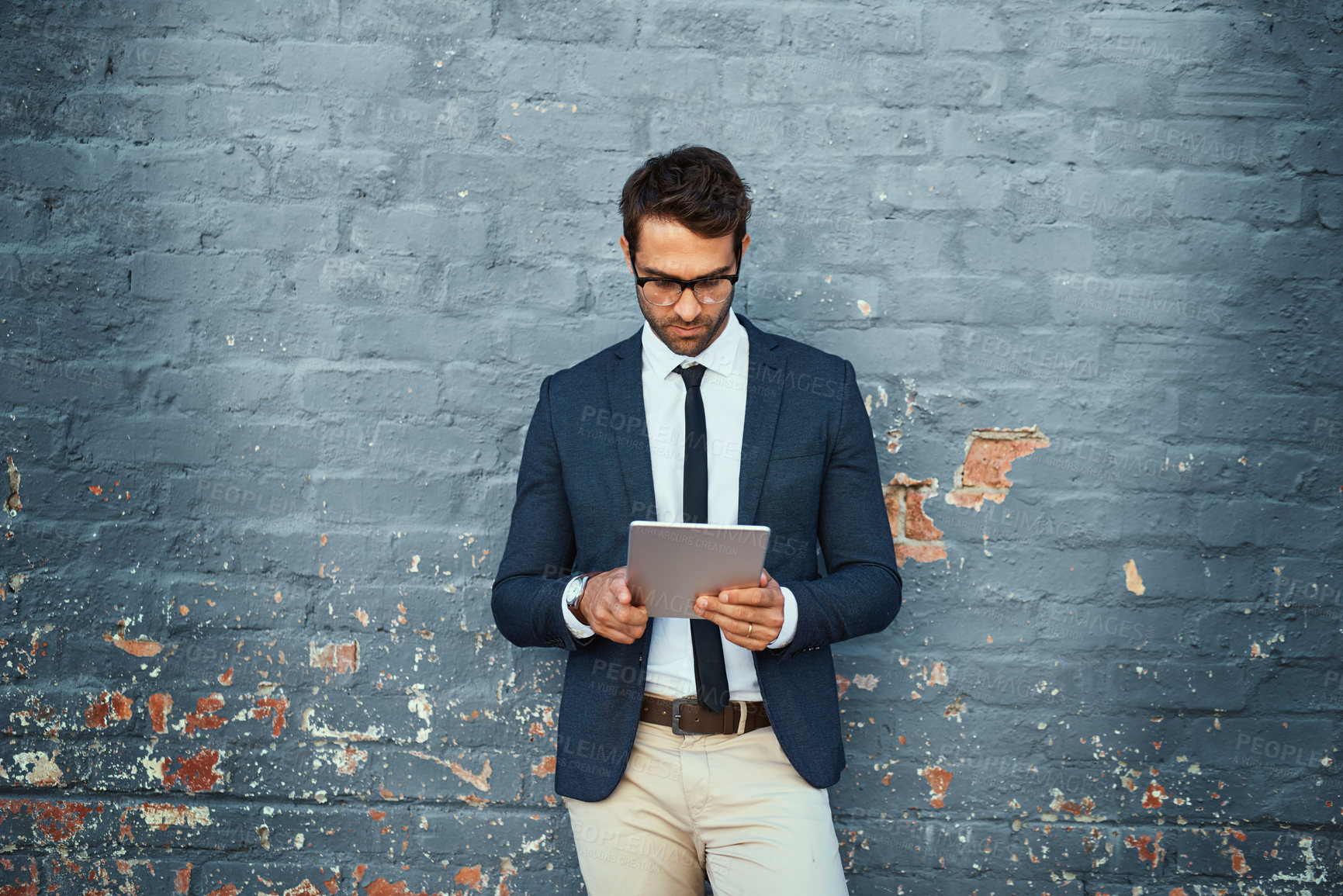 Buy stock photo Businessman, fashion and tablet in formal wear for connection on brick wall or city background. Male person, style and trendy with pride, outdoor and technology in office clothes as real estate agent