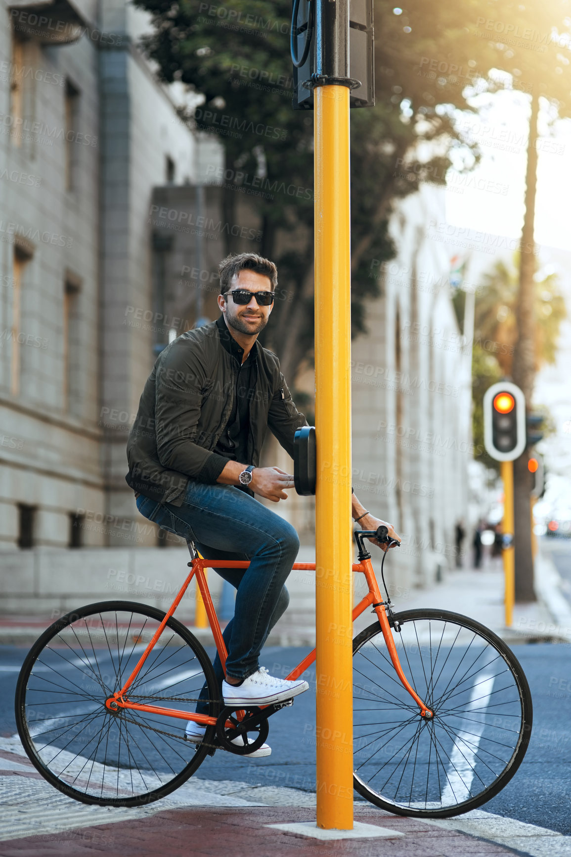Buy stock photo Full length shot of a handsome young man traveling through the city by bike