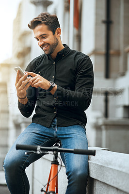 Buy stock photo Cropped shot of a handsome young man sending a text while traveling through the city