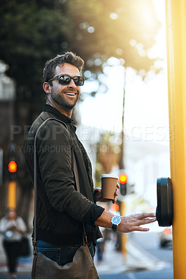 Buy stock photo Cropped shot of a handsome young man pressing the crosswalk button on a traffic light while traveling through the city