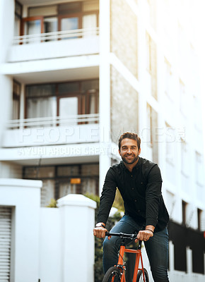 Buy stock photo Cropped portrait of a handsome young man traveling through the city by bike