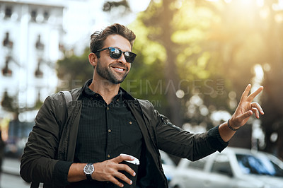 Buy stock photo Cropped shot of a handsome young man hailing a cab in the city