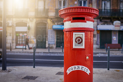 Buy stock photo Shot of a red mailbox standing on its own in the city outside during the day