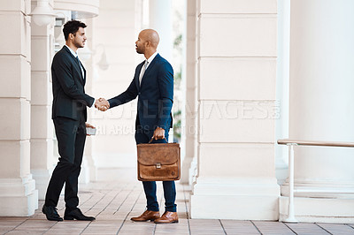 Buy stock photo Shot of young handsome businessmen shaking hands outside