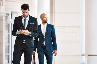 Buy stock photo Cropped shot of a young handsome businessman using a cellphone outside