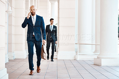 Buy stock photo Shot of a young handsome businessman on a call outside
