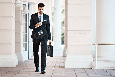 Buy stock photo Shot of a young handsome businessman on a call outside