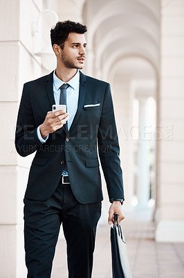 Buy stock photo Cropped shot of a young handsome businessman using a cellphone outside