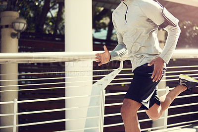 Buy stock photo Cropped shot of an unrecognizable man running on a bridge in the city
