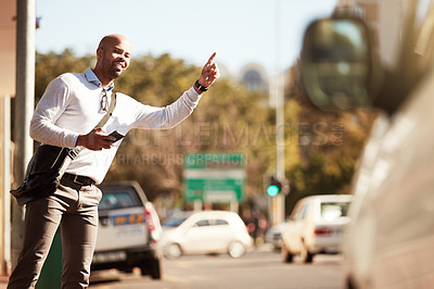 Buy stock photo Cropped shot of a handsome young businessman hailing a ride in the city