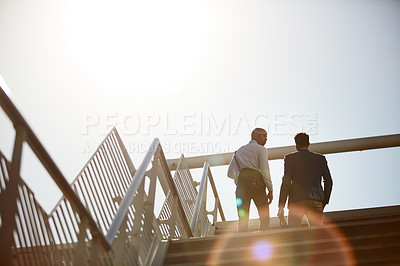 Buy stock photo Low angle shot of unrecognizable businessmen talking on top of a staircase outside