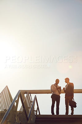 Buy stock photo Low angle shot of two businessmen talking on top of stairs outside