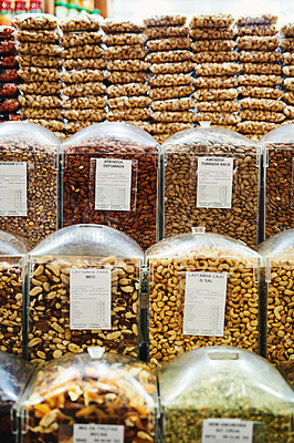 Buy stock photo Shot of a whole bunch of containers and packets full of nuts that are being displayed at a market
