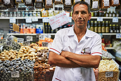 Buy stock photo Portrait of a confident middle aged man standing with his arms folded at his market stall outside during the day