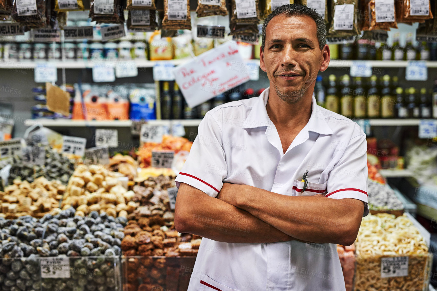 Buy stock photo Portrait of a confident middle aged man standing with his arms folded at his market stall outside during the day