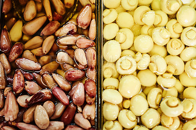 Buy stock photo Shot of mushrooms and pine nuts displayed next to each other at a market during the day