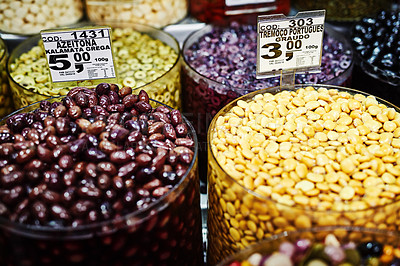 Buy stock photo Shot of numerous amounts of red olives and nuts in containers being displayed at a market during the day