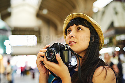 Buy stock photo Shot of a carefree young woman taking photos of a food market during the day