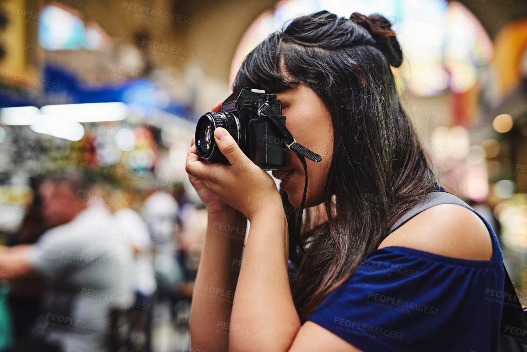 Buy stock photo Shot of a carefree young woman taking photos of a food market during the day