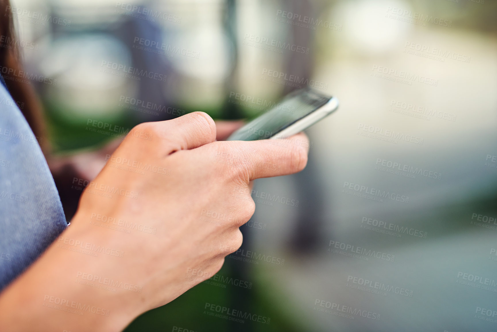 Buy stock photo Closeup shot of an unrecognizable businesswoman using a cellphone outside