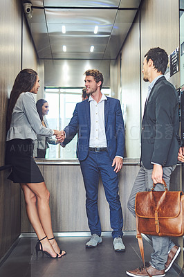 Buy stock photo Shot of businesspeople meeting and greeting in an elevator