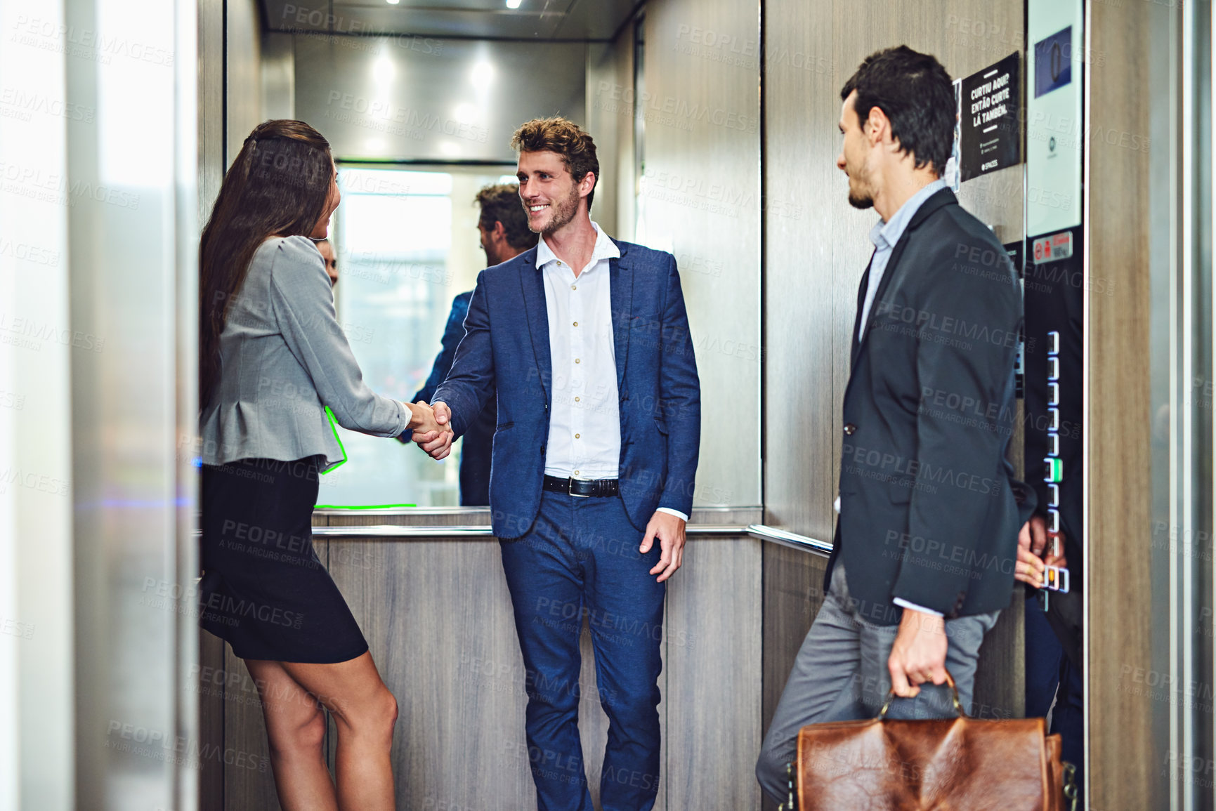 Buy stock photo Cropped shot of businesspeople meeting and greeting in an elevator