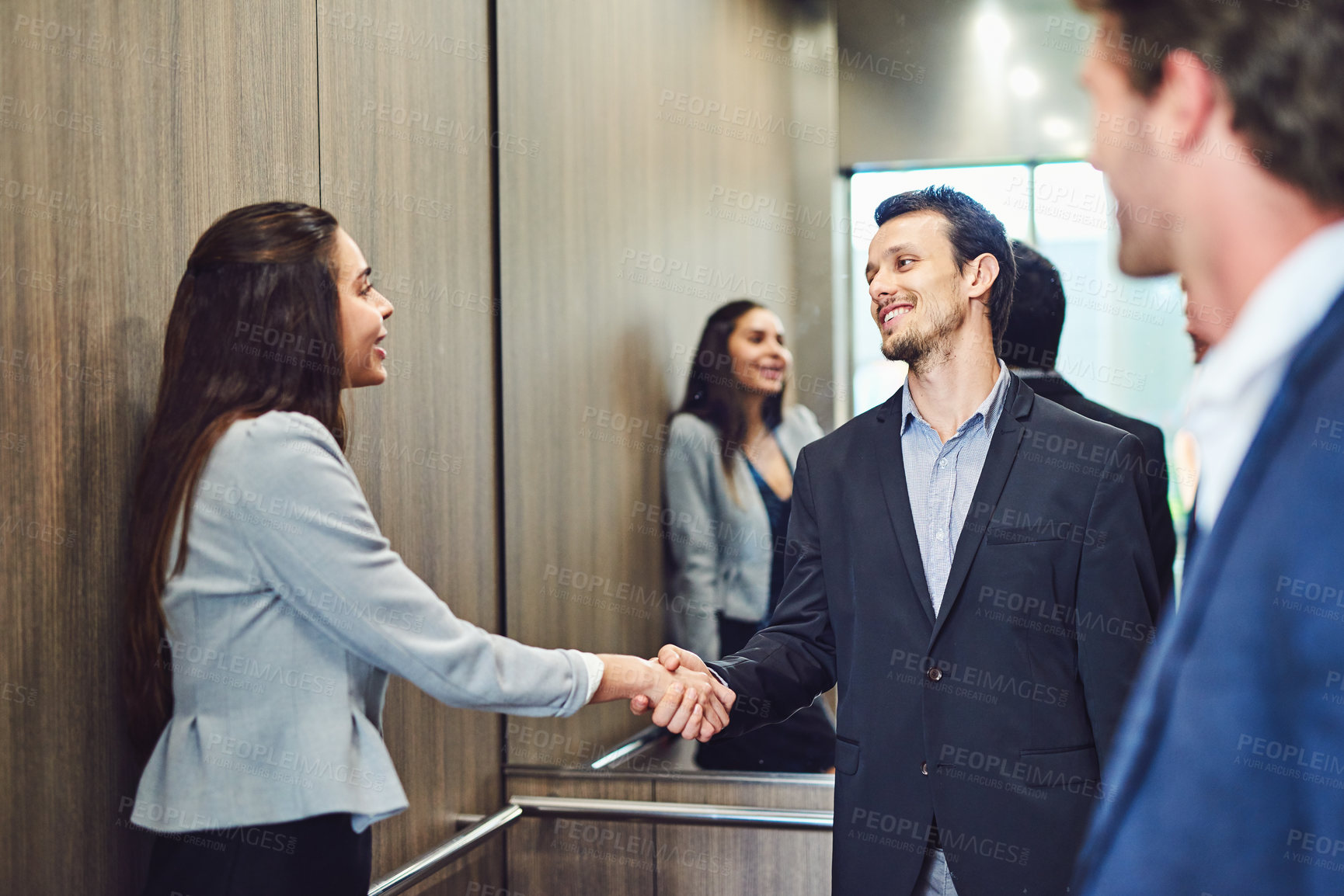 Buy stock photo Cropped shot of businesspeople meeting and greeting in an elevator