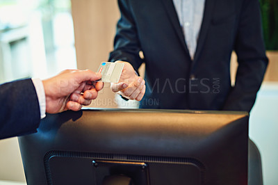 Buy stock photo Cropped shot of an unrecognizable businessman checking in and paying with a credit card in a hotel