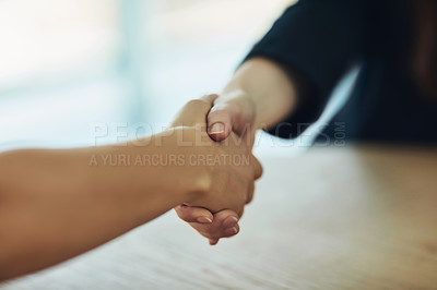 Buy stock photo Cropped shot of two businesswomen shaking hands in a modern office