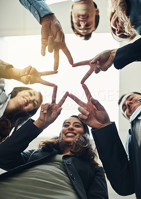 Buy stock photo Low angle shot of a group of young businesspeople joining their hands in a modern office