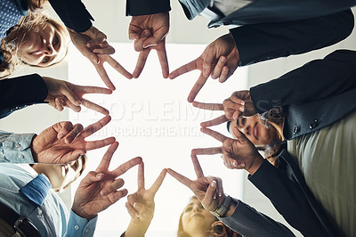 Buy stock photo Low angle shot of a group of young businesspeople joining their hands in a modern office