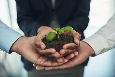 Buy stock photo Cropped shot of a group of businesspeople holding a plant growing out of soil