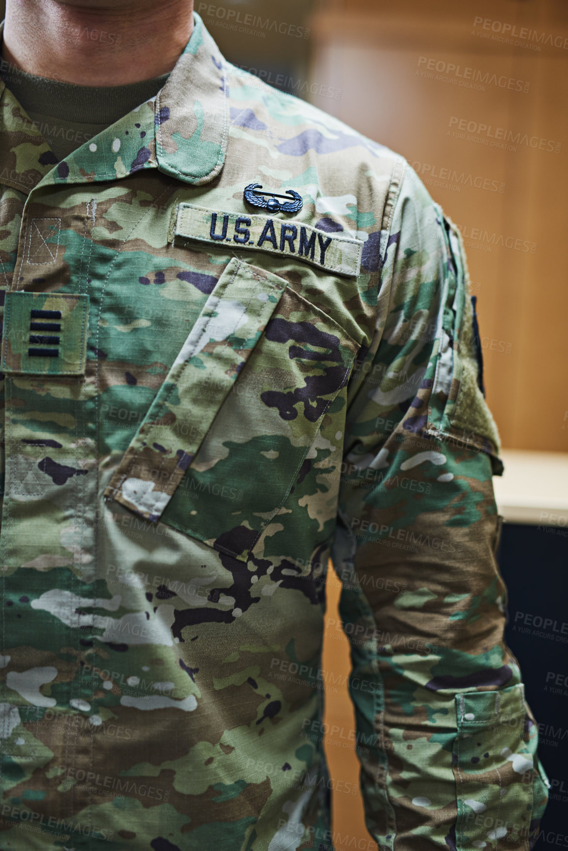 Buy stock photo Cropped shot of a soldier wearing camouflage fatigues with a badge attached to velcro on his chest