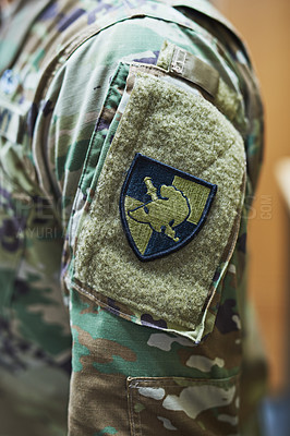 Buy stock photo Cropped shot of a soldier wearing camouflage fatigues with a patch attached to velcro on his sleeve