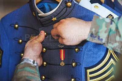 Buy stock photo Cropped shot of a soldier pinning a medal to his jacket