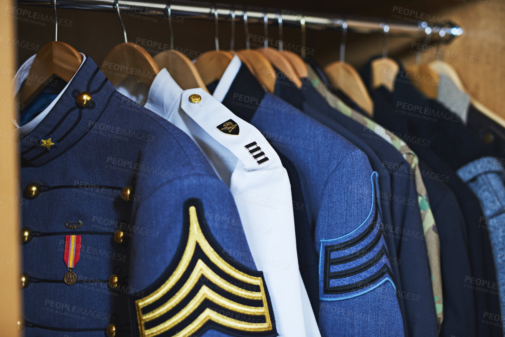 Buy stock photo Shot of various military jackets hanging in a closet
