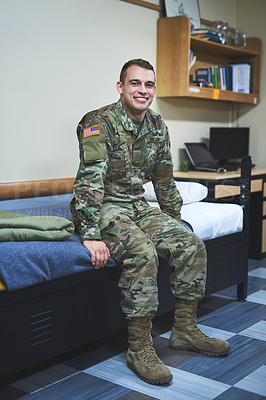 Buy stock photo Shot of a young soldier sitting on his bed in the dorms of a military academy