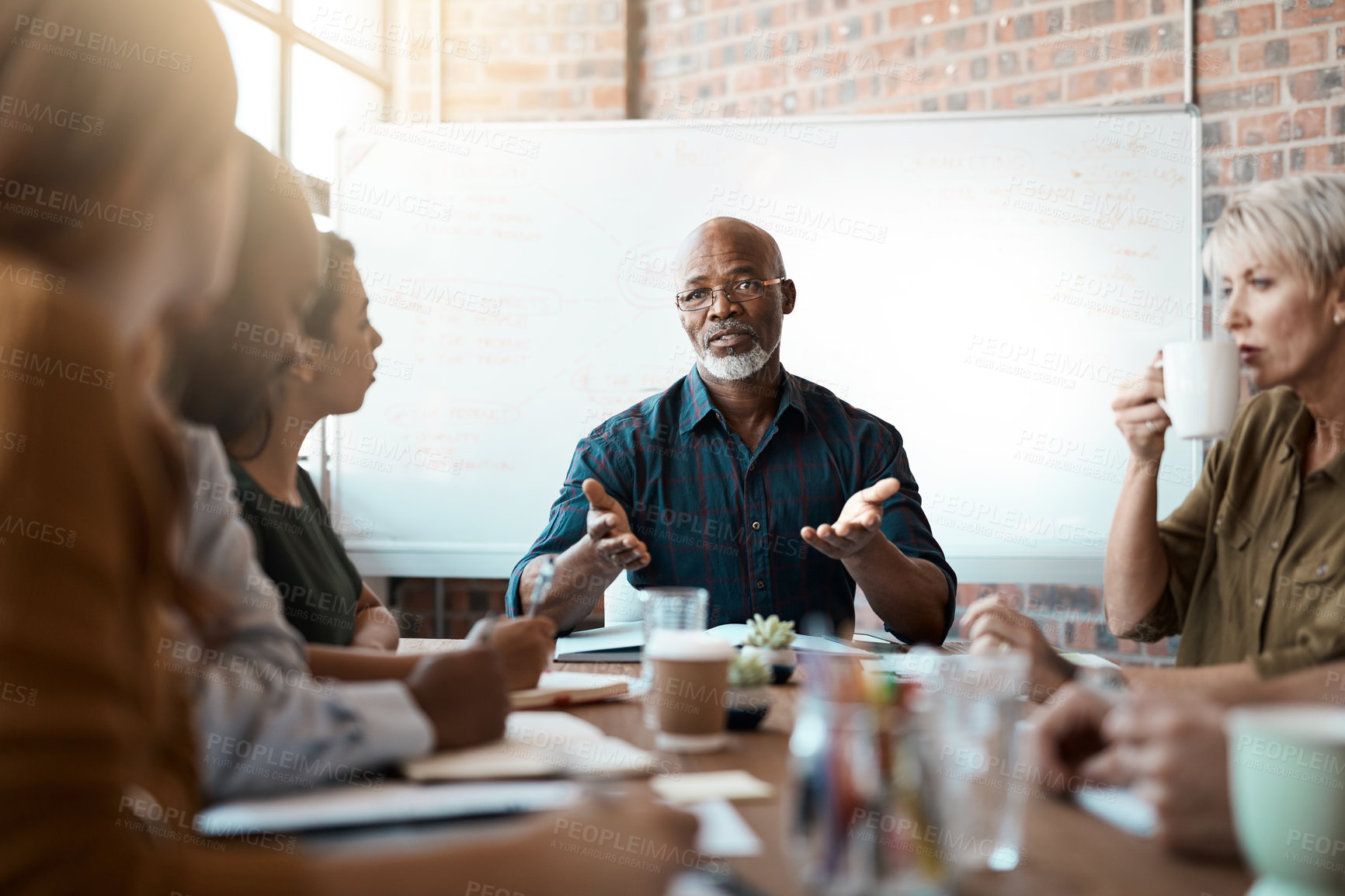 Buy stock photo Meeting leader, business people and black man in office, talking or speaking. Teamwork, ceo and senior African male mentor coaching, training or planning strategy with mockup in corporate workplace.