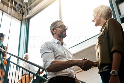 Buy stock photo Shot of two businesspeople talking to each other while standing on a stairwell