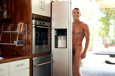 Buy stock photo Cropped shot of a handsome young shirtless man getting items from the refrigerator at home