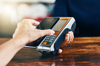 Buy stock photo Closeup of an unrecognizable person using her phone to scan and pay a bill on a card machine at a cafe during the day