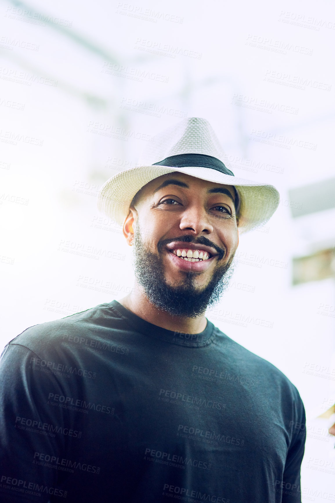 Buy stock photo Low angle portrait of a handsome young man wearing a hat