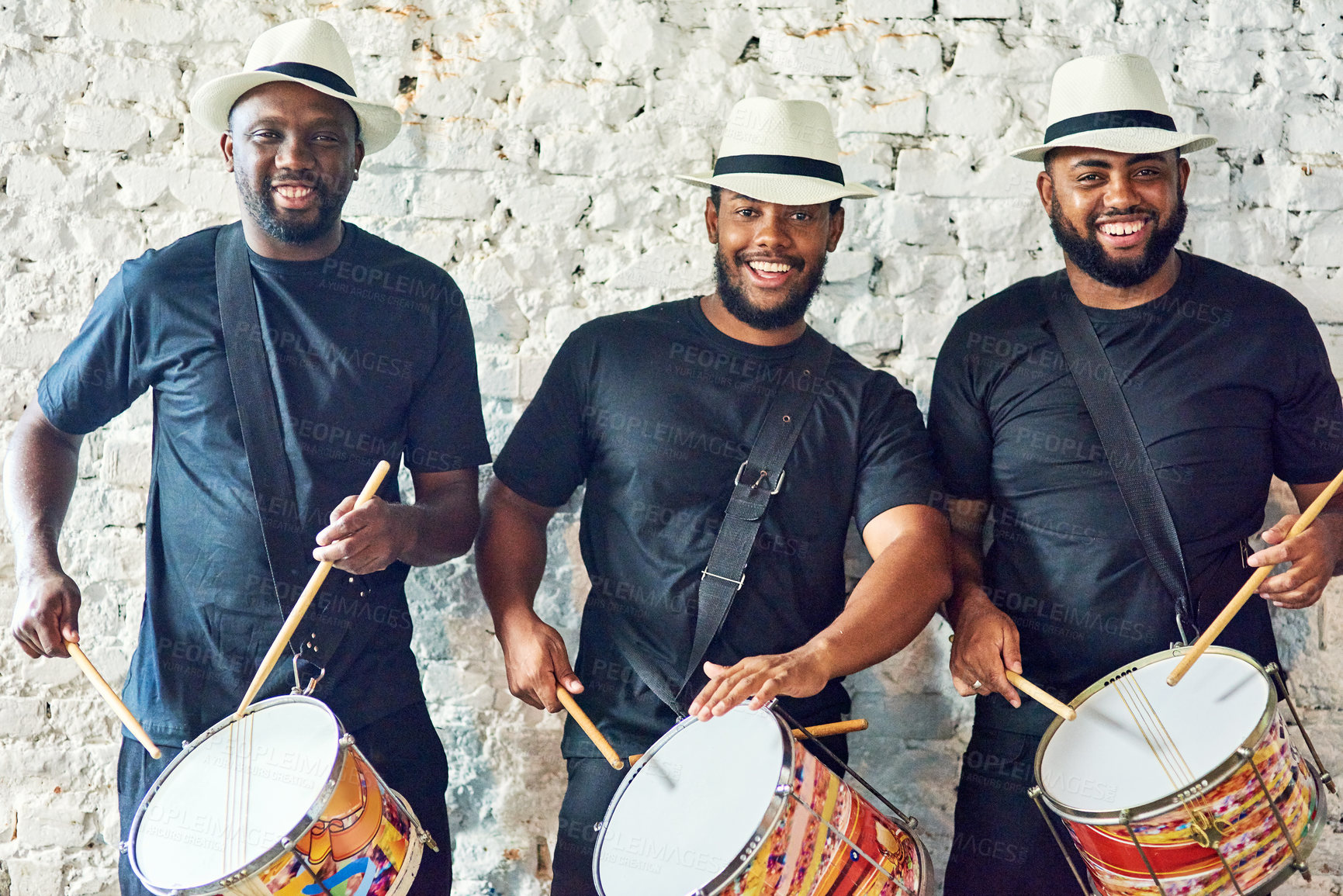 Buy stock photo Cropped portrait of a group of handsome young male drummers playing at Carnival