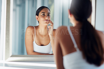 Buy stock photo Cropped shot of an attractive young woman inspecting her skin in front of the bathroom mirror