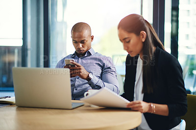 Buy stock photo Shot of two businesspeople working in an office