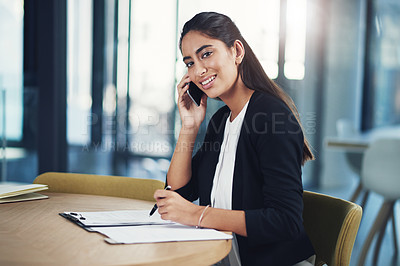 Buy stock photo Portrait of a young businessman talking on a cellphone in an office