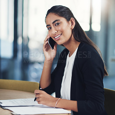 Buy stock photo Portrait of a young businessman talking on a cellphone in an office