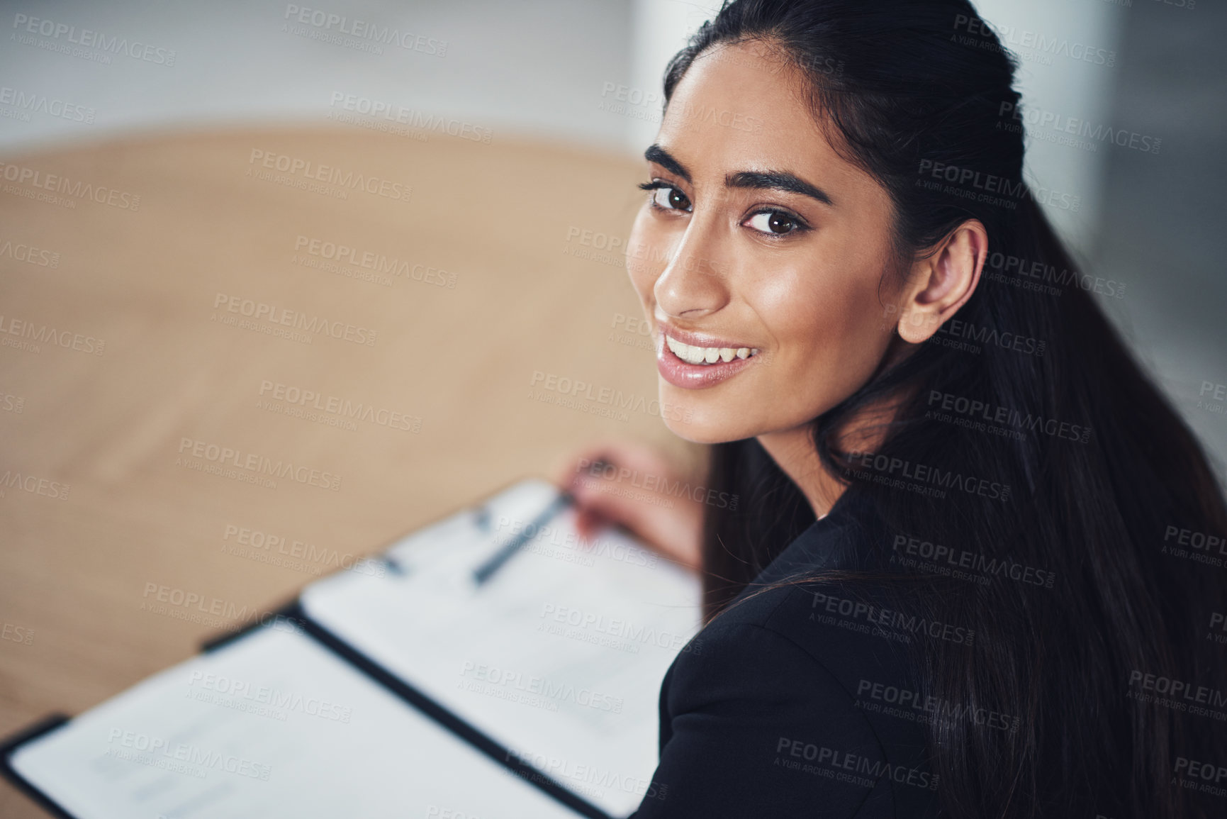Buy stock photo Portrait of a young businesswoman going through some paperwork in an office