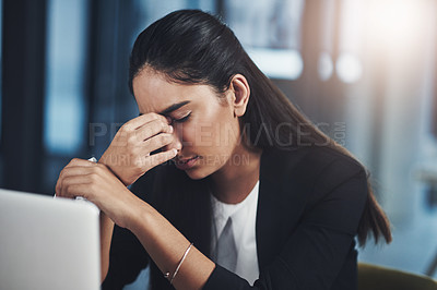 Buy stock photo Shot of a young businesswoman suffering with a headache while working in an office
